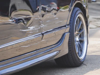 Focus at damaged scratch on surface of black car parked on the street after accident
